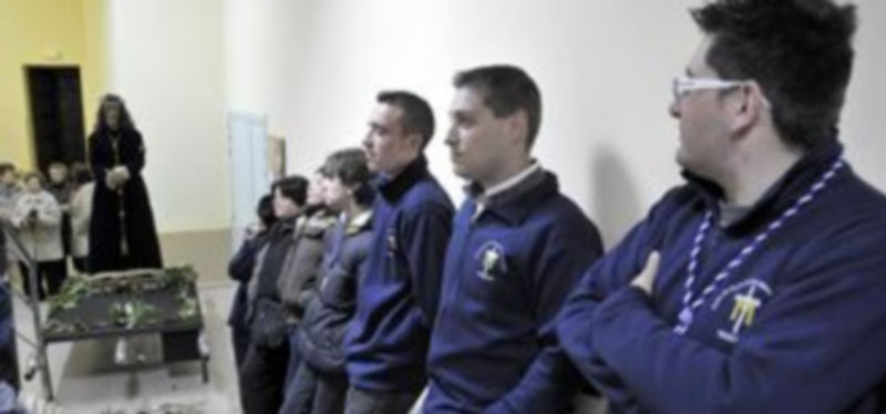 Un grupo de cofrades espera ante la imagen el inicio de la procesión