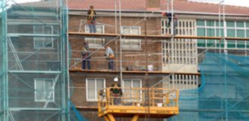 Imagen de archivo de varios operarios de la construcción trabajando en la fachada de un edificio. / Alberto Benavente