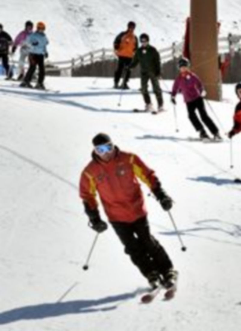Un grupo de jóvenes practicando esquí en una estación invernal. / Kamarero.