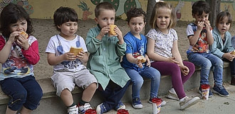 Los niños toman los bocadillos preparados por la AMPA para recaudar fondos destinados a Menudos corazones. /T.D. S.