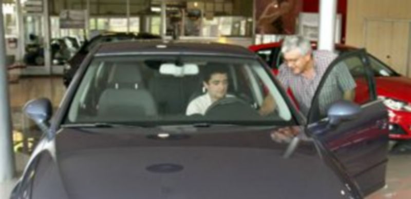 Un responsable de ventas de un concesionario segoviano muestra uno de sus vehículos del expositor a un potencial cliente. / Alberto Benavente