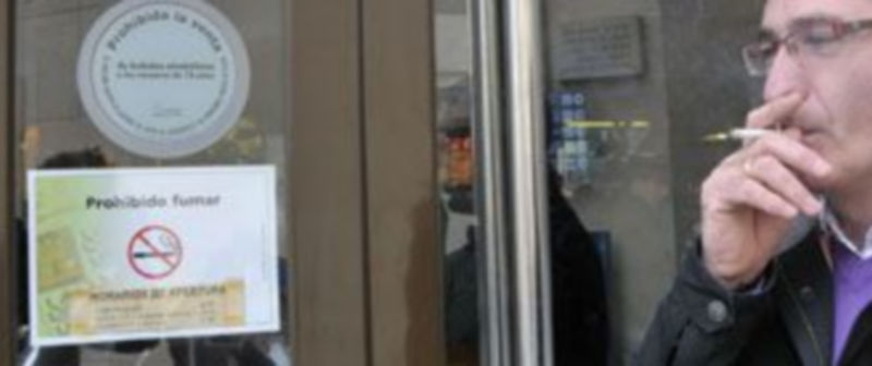 Un hombre se fuma un cigarrillo a la puerta de un establecimiento en el que está prohibido fumar. / Alberto Benavente