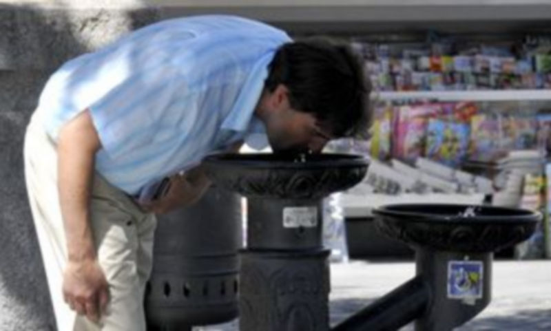 Una persona se refresca bebiendo agua en una fuente pública de Segovia hace unos días. / Juan Martín