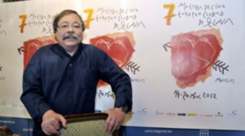 El diseñador Alberto Corazón junto a su cartel de la VII Edición de MUCES./ Juan Martín