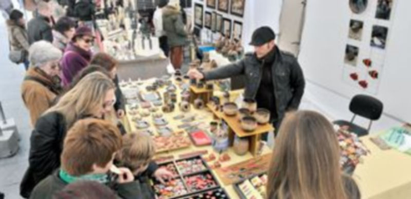 El público llena los puestos de los feriantes buscando la belleza de las formas y la posibilidad de llevar a cabo regalos con los que adelantar la Navidad. / Kamarero.