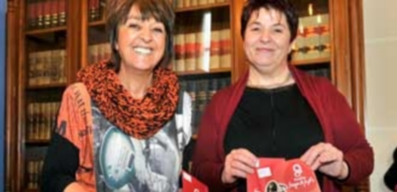 Las concejalas Claudia de Santos y Clara Luquero muestran los carteles conmemorativos de la celebración.  / Kamarero