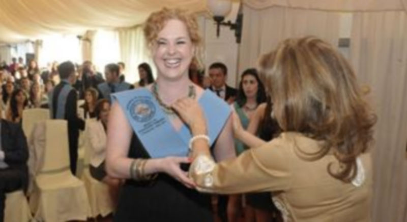 Una de las alumnas recibe con alegría la beca de graduada. / Juan Martín