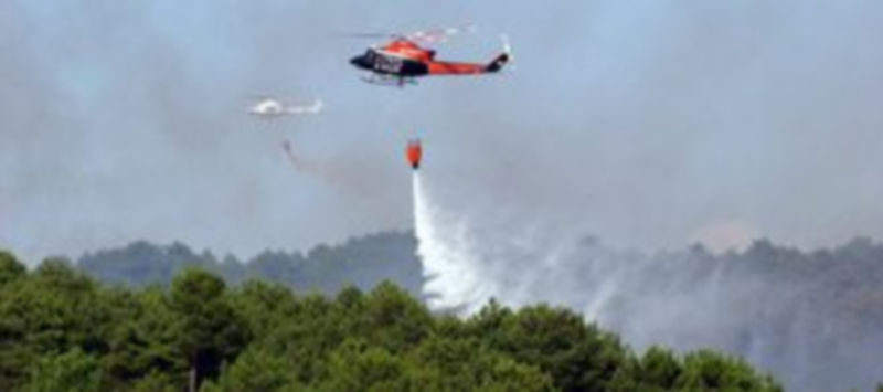 Dos de los helicópteros que participaron en las labores de extinción del fuego. / Luis Horcajo de Frutos