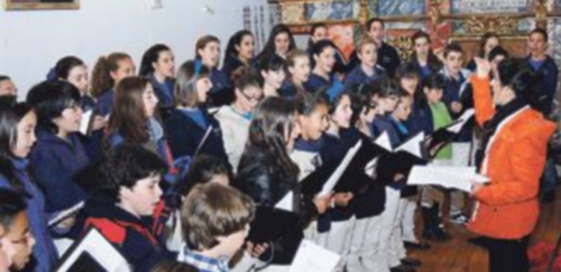 Alumnos del coro de la Escolanía de Segovia en uno de sus numerosos ensayos junto a su profesora María Luisa. / El Adelantado