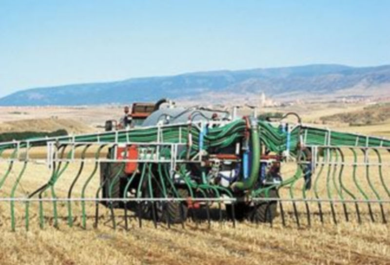 Un tractor con una cuba de purín esparce el residuo ganadero por un campo de tierra./El Adelantado