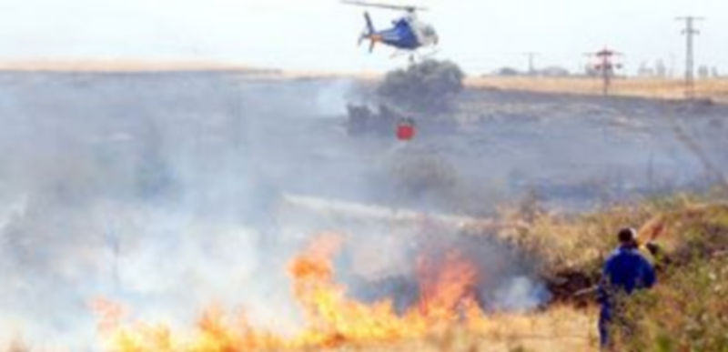 Personal de la Consejería de Medio Ambiente de la Junta de Castilla y León y un helicóptero intentando sofocar un incendio acaecido en la provincia de Segovia./ Juan Martín.