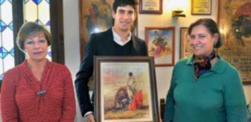 Dos contertulianas flanqueando a López Simón con el óleo de Lope Tablada. / Kamarero