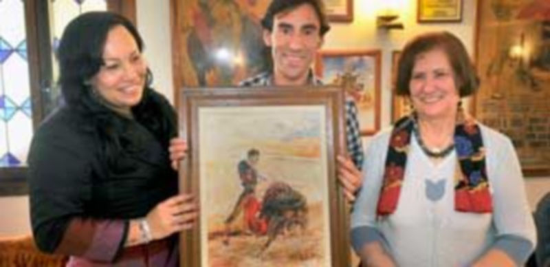 Fernando Cruz junto a dos contertulias y el óleo de Tablada. / Kamarero