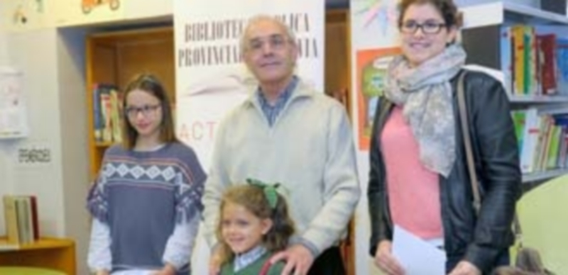 El director de la biblioteca posa con las ganadoras de los concursos tras la entrega de premios. / Kamarero