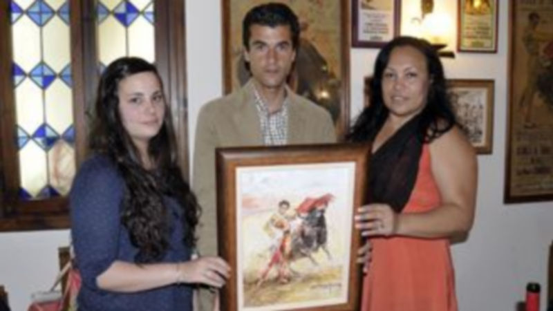 Rafael de Julia con la alcaldesa de las fiestas y una tertuliana mostrando el óleo de Tablada. / JUAN MARTÍN