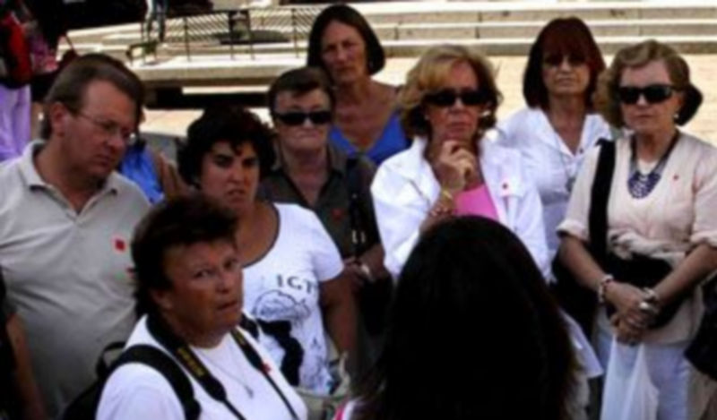 Un grupo de personas atiende las explicaciones de una guía turística. / A. B.