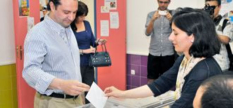 La presidenta de la mesa introduce la papeleta de Pedro Arahuetes. / Kamarero.