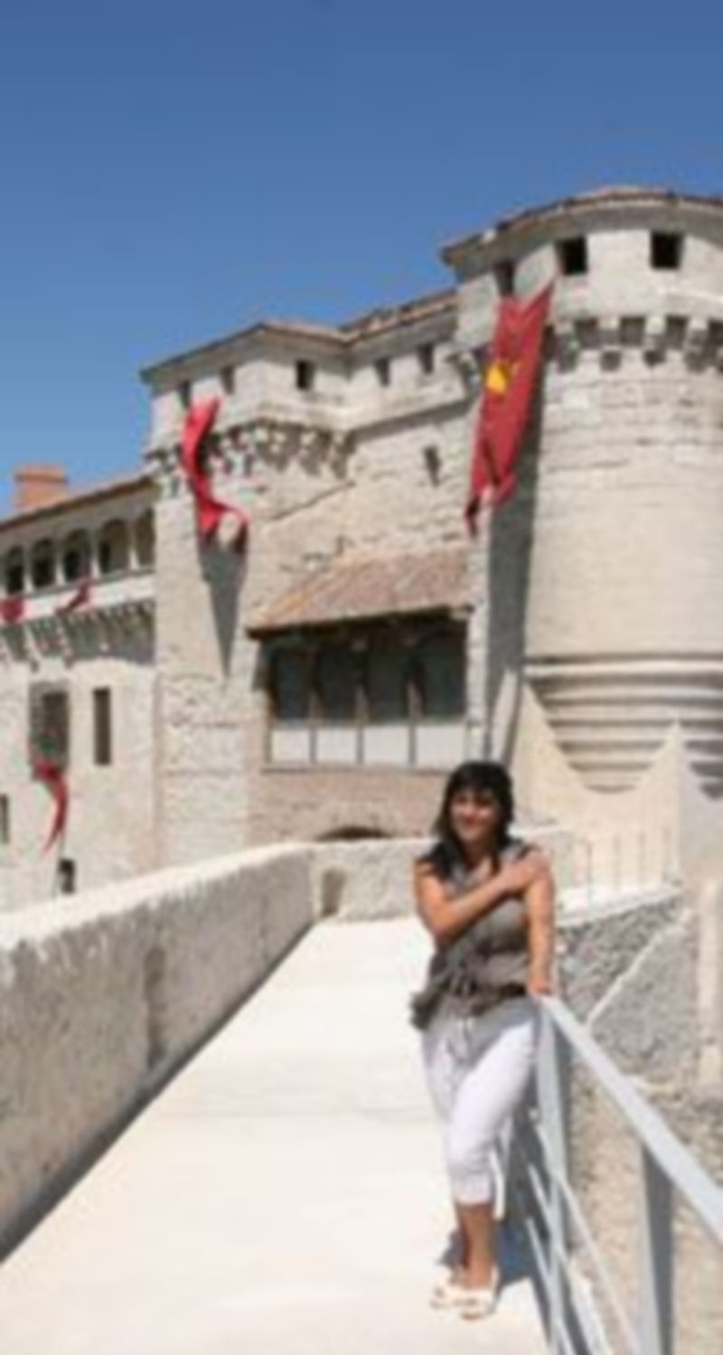 La concejala de Turismo muestra desde el paseo de ronda la decoración instalada ya en el Castillo y murallas. / Nuria Pascual