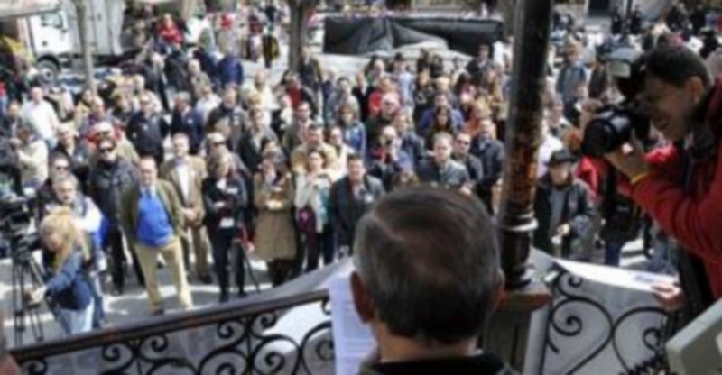 Alfredo Matesanz -de espaldas- lee el manifiesto en presencia de periodistas y ciudadanos en la Plaza Mayor. / J. Martín.