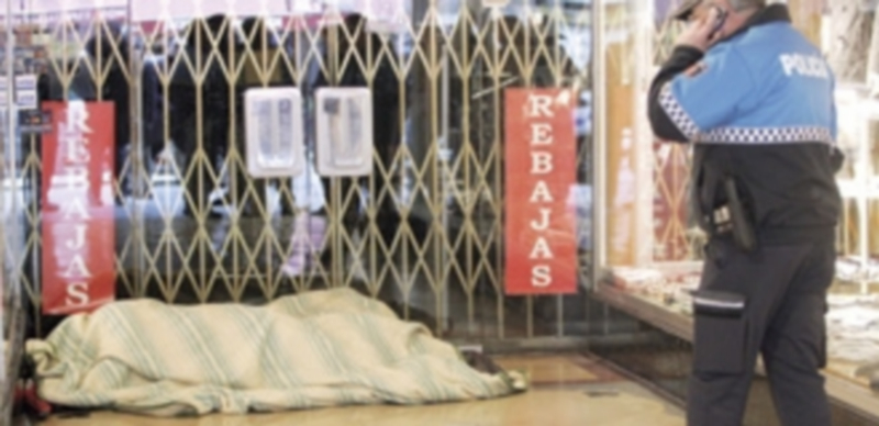 Un policía custodia el cadáver del indigente que perdió ayer la vida en León. / Ical