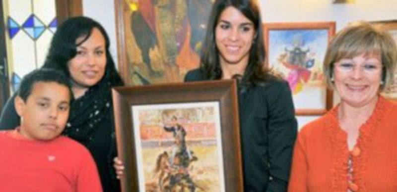 Lea Vicens muestra el óleo de Lope Tablada junto a dos contertulias. / Kamarero