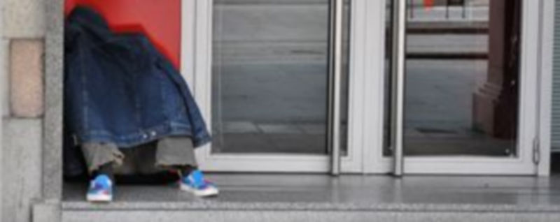 Una persona duerme en un portal de una calle de la capital./Kamarero