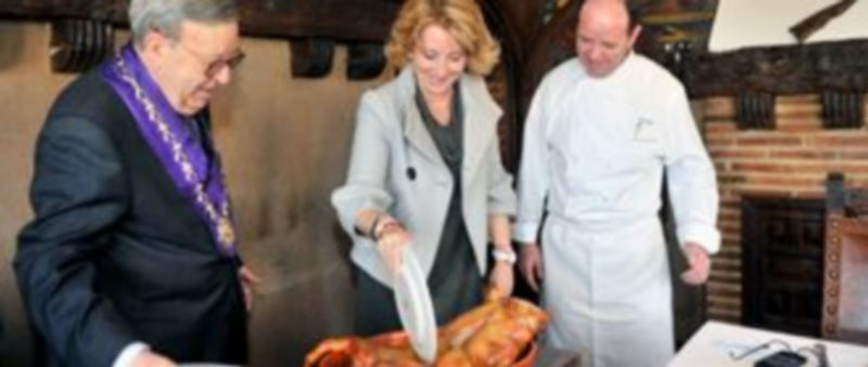 Esperanza Aguirre parte el cochinillo a la manera tradicional junto a Alberto y Cándido López. / Kamarero