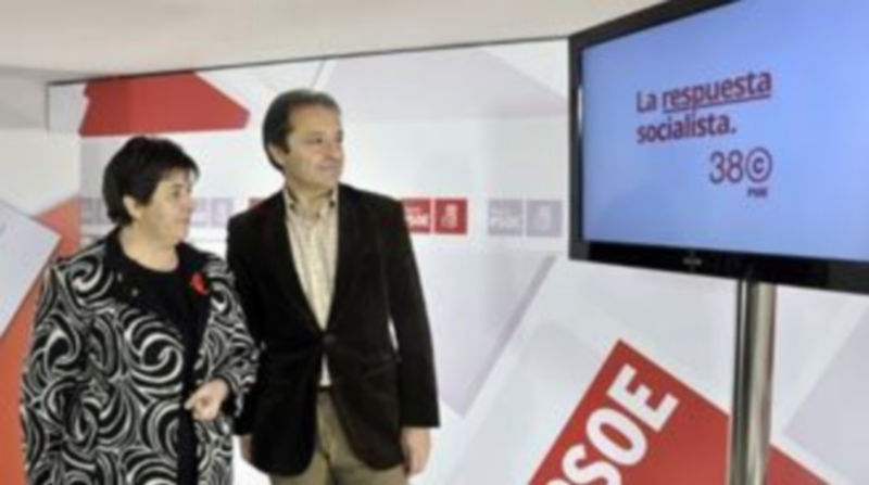 Clara Luquero y Juan Luis Gordo observan el lema y el logotipo del Congreso Federal del PSOE en Sevilla. /Juan Martín