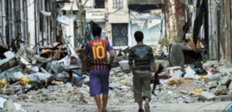 Unos jóvenes recorren las calles de Damasco después de un ataque con fuego de mortero. / Reuters