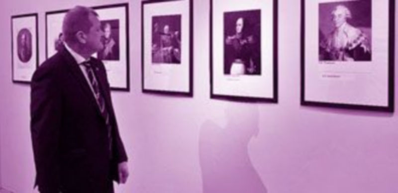 Uno de los agregados culturales de la embajada rusa en España observa los cuadros de la exposición. / Kamarero