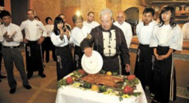 El chef Gil Martínez Soto realiza una demostración culinaria con un cochinillo asado en el Programa Gastronómico del Pabellón de España. / ICAL