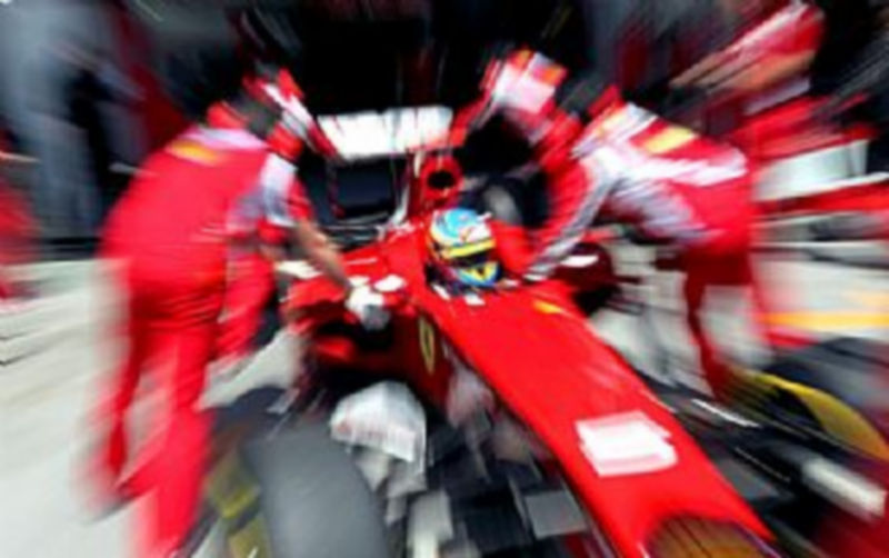 Mecánicos empujan el monoplaza de Fernando Alonso. / EFE