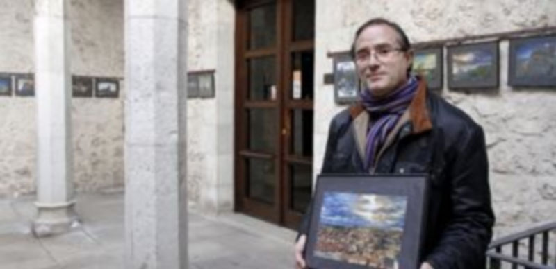 Juan Carlos de la Fuente con una de sus fotografías en las manos en el patio del Ayuntamiento. / Gabriel Gómez
