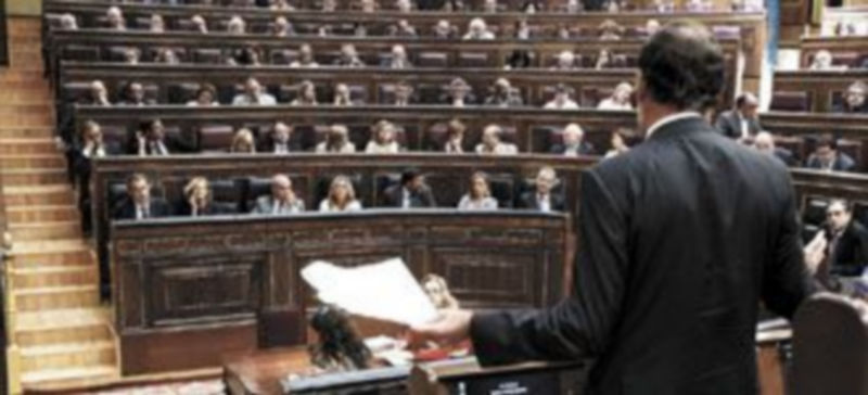 El líder ‘popular’ (de espaldas) se dirige al Pleno del Congreso desde su escaño de diputado en la sesión del lunes en la que se anunció la propuesta. / Emilio Naranjo (EFE)
