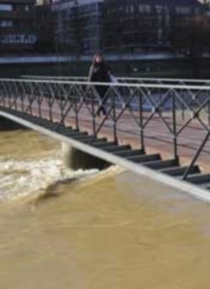 La cuenca del Duero tiende a normalizarse tras las crecidas 1 Una mujer cruza el río Bernesga a su paso por la capital leonesa. / Efe