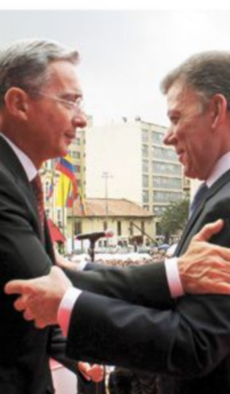 Uribe (i) y Santos se abrazan durante la ceremonia de investidura del nuevo presidente colombiano. / César Carrión (Reuters)