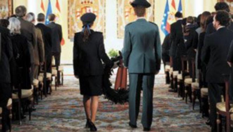 Una agente de la Policía y un guardia civil fueron los encargados de depositar una corona en honor y recuerdo de sus compañeros fallecidos a lo largo del pasado año. / Efe