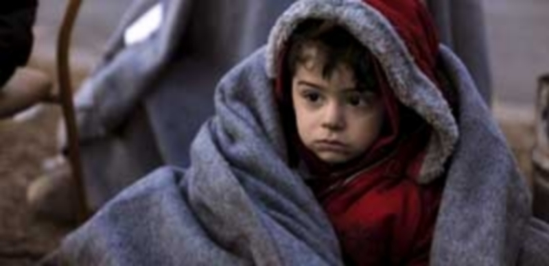Un niño migrante cubierto con una manta en el campo de refugiados griego de Idomeni