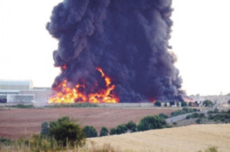 La densa columna de humo generada por el incendio de la planta de reciclaje. / EFE