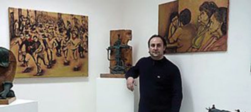 Dyango Velasco  junto a algunas de las obras de la exposición.
