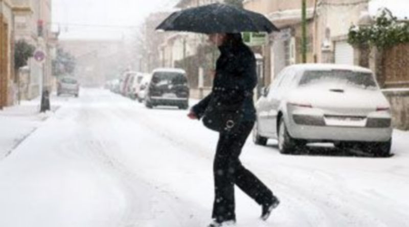 Una mujer intenta cruzar una calle completamente nevada en Burgos. /ICAL