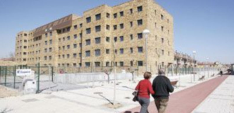 Dos personas pasean delante de un edificio de viviendas de protección oficial en Valladolid. / ICAL