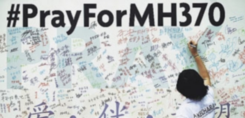 Una mujer escribe un mensaje por el vuelo desaparecido MH370. / S. S. (Reuters)