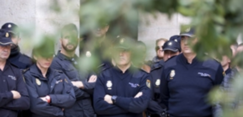 Miembros de la Policía Nacional en Almería guardan un minuto de silencio por el inspector accidentado en la expedición. / Efe