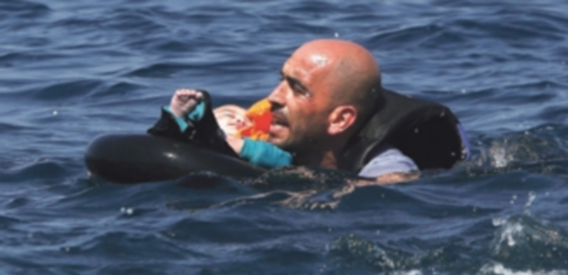 Un voluntario ayuda a un niño en el naufragio de dos embarcaciones de inmigrantes en las costas griegas. / Europa Press