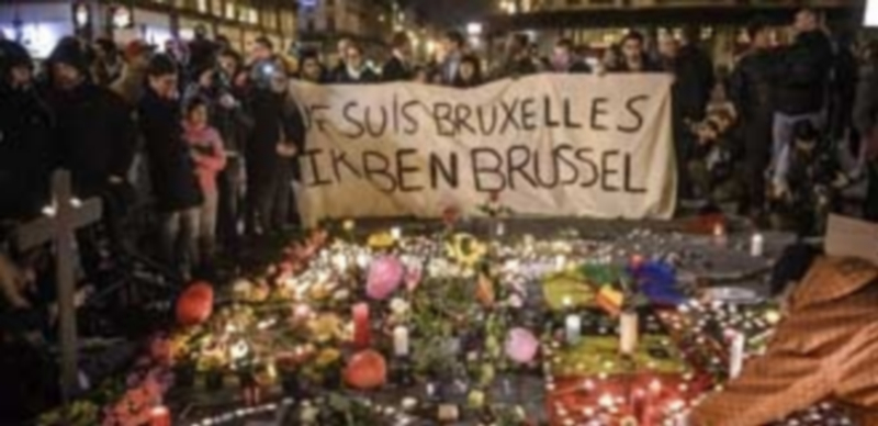 Varias personas se reúnen en la plaza Bourse de Bruselas para homenajear a los más de 30 fallecidos y al menos 200 heridos por los atentados perpetrados ayer sobre la capital de Bélgica. / EFE