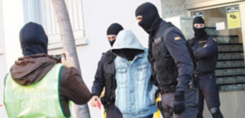 Agentes de la Guardia Civil escoltan a uno de los detenidos en Badalona. / Efe