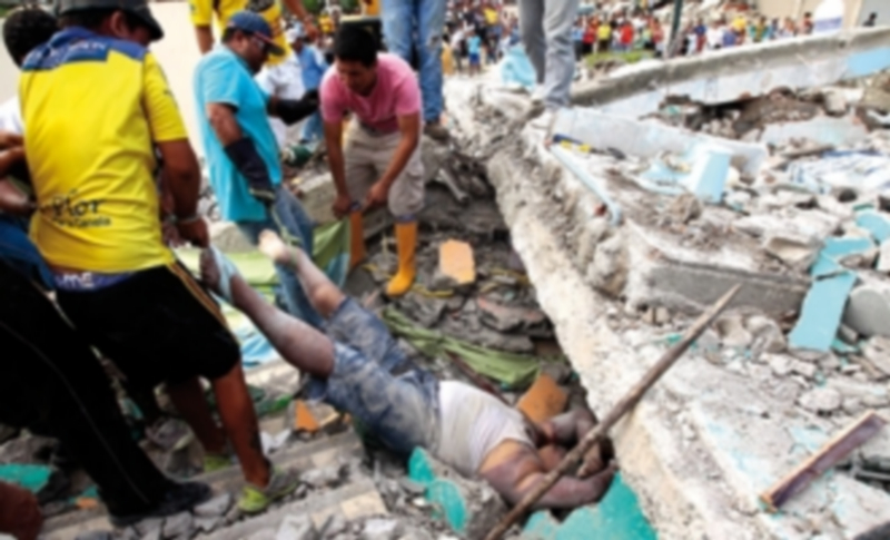 un grupo de personas rescatan un cuerpo sin vida entre los escombros en Pedernales