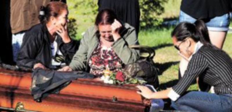 Familiares de una de las víctimas del incendio de Kiss lloran sobre el féretro en uno de los primeros entierros celebrados en Brasil. / Reuters