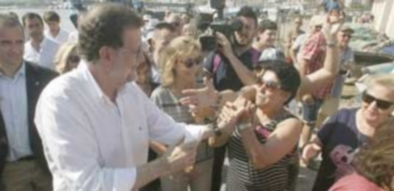 Mariano Rajoy saluda a varios simpatizantes durante su paseo por la localidad alicantina de Santa Pola. / Efe